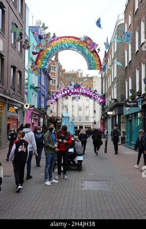 Carnaby Street. Le persone camminano in questa strada iconica già decorata per la stagione delle feste. Foto Stock