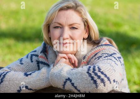Attraente premurosa donna di mezza età appoggiata in appoggio sulla recinzione in campagna Foto Stock