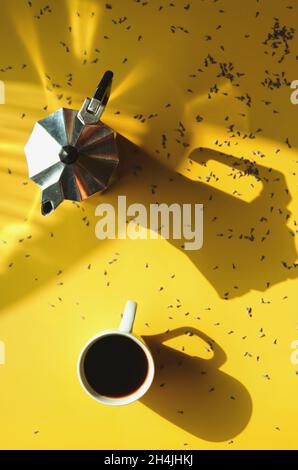 mattina di lavoro con tazza di caffè caldo, croissant dolce e bouquet di lavanda su sfondo giallo. Vista dall'alto, spazio di copia, mockup. Disposizione piatta. Foto Stock