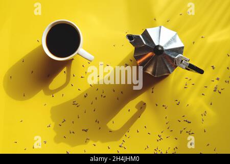 mattina di lavoro con tazza di caffè caldo, croissant dolce e bouquet di lavanda su sfondo giallo. Vista dall'alto, spazio di copia, mockup. Disposizione piatta. Foto Stock