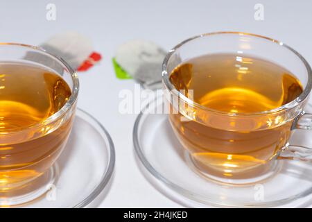 Due tazze di tè in foglie di Darjeeling tenuti su un tavolo con bustine di tè Foto Stock