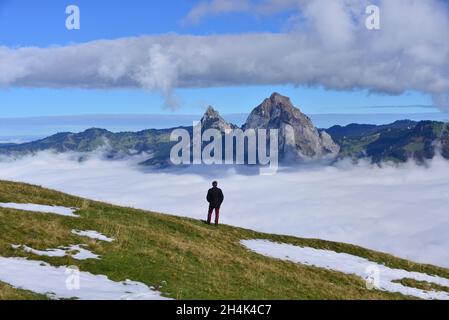 Vista posteriore di un uomo che guarda il paesaggio montano di Grosser Mythen, Stoos, Canton Schwyz, Svizzera Foto Stock