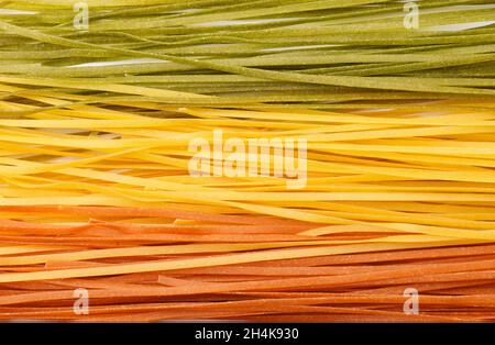 Primo piano di pasta a nastro lungo multicolore non cotta Foto Stock