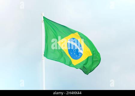 Bandiera del Brasile che sventola nel vento su un flagpole Foto Stock