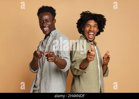 Gotcha. Due allegre guys afroamericani Poiting Fingers at Camera, gioiosi giovani amici maschi neri dicendo Hey You, Laughing and Having Fun While po Foto Stock