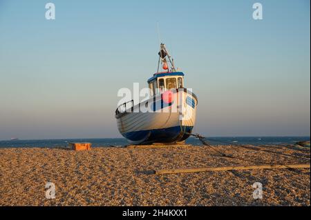 Piccola barca da pesca trainato sulla spettacolare spiaggia di Dungeness Foto Stock