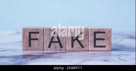 FALSA parola fatta con blocchi di costruzione isolati su blu Foto Stock