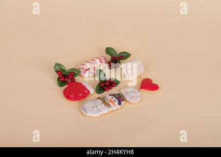 Modello creativo realizzato con biscotti fatti in casa di pan di zenzero isolati su sfondo beige. Composizione minimale di Natale alla moda. Foto Stock