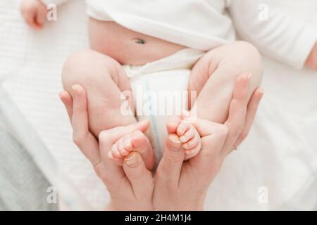Madre che cambia un pannolino a bambina piccola. Foto Stock