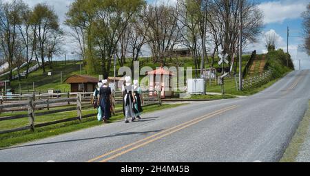 Adolescenti Amish ragazzi e ragazze che camminano lungo una strada rurale in campagna in un giorno di primavera Foto Stock