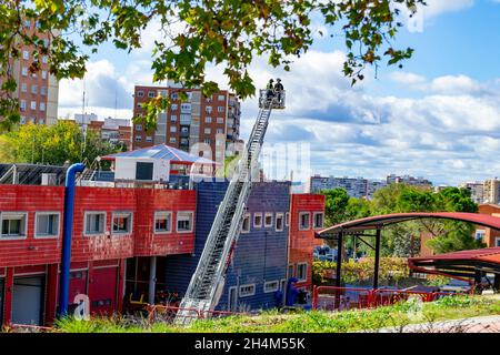 I vigili del fuoco salgono su una scala di camion in uno degli allenamenti nella stazione dei vigili del fuoco, a Madrid, Spagna. Europa. Foto Stock