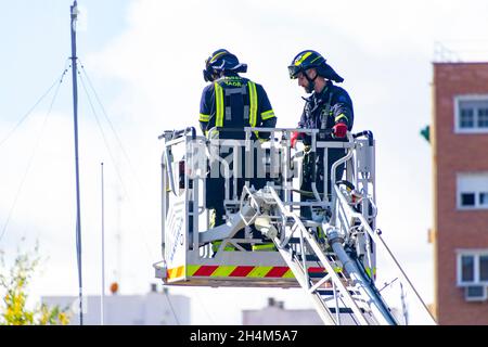 I vigili del fuoco salgono su una scala di camion in uno degli allenamenti nella stazione dei vigili del fuoco, a Madrid, Spagna. Europa. Foto Stock