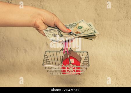 Casa rossa con una pila di fatture del dollaro. Il concetto di acquisto di una casa. Foto Stock