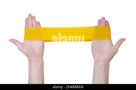 Fitness gengive elastico fascia gialla in mani isolate su sfondo bianco. Sport Concept - espansore elastico. Stile di vita sano. Allenamento cardio a casa i Foto Stock