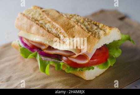 Sandwich sottomarino fresco con prosciutto, formaggio, pomodori e lattuga Foto Stock