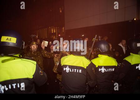 L'Aia, Paesi Bassi. 2 novembre 2021. La polizia si scontra con i manifestanti, durante la manifestazione. La polizia ha arrestato tredici persone durante una manifestazione anti-corona, come le nuove misure del Covid 19 sono state annunciate dal primo ministro olandese uscente, Mark Rutte. Qualche centinaio di persone si sono riunite fuori dal “Ministero della Giustizia e della sicurezza” sul Turfmarkt, con il suono assordante di fischi, grida, musica, il banging di pentole e tamburi da cucina, e le occasionali fuochi d’incendio e razzi rossi. Credit: SOPA Images Limited/Alamy Live News Foto Stock