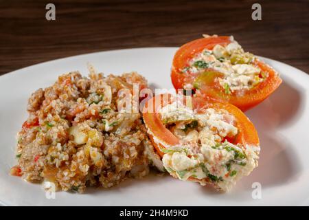 Insalata di tabbouleh con pomodoro ripieno. Cibo vegetariano. Piatto tradizionale medio-orientale o arabo. Vista dall'alto Foto Stock