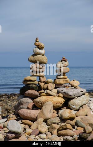 Cairns è stata costruita dai visitatori del castello di Lindisfarne su Holy Island, al largo della costa del Northumberland, nel nord-est dell'Inghilterra, Regno Unito. Foto Stock