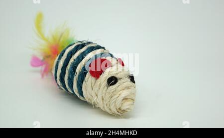 Mouse di gioco fatto di corda e piume per gatti. Sfondo bianco e spazio per posizionare il testo Foto Stock