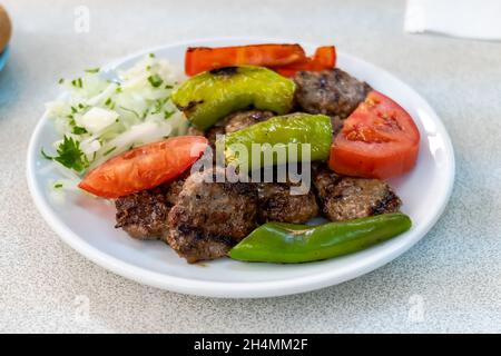 Izgara kofte, piatto tradizionale turco di polpette, grigliato con verdure sul piatto. Cucina turca foto Foto Stock
