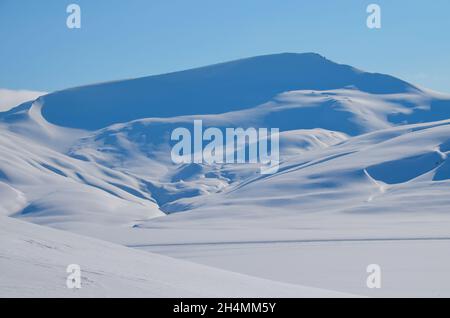 La magica bellezza di Svalbard. Insolitamente la neve blu contro il cielo limpido. Vette innevate sull'isola di Svalbard Foto Stock