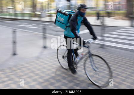 Un autista di consegna Wolt guida la sua bicicletta nel centro storico della capitale Lubiana, Slovenia, 13.10.2021. Foto Stock