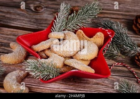 Biscotti natalizi fatti in casa a mezzaluna chiamati 'Vanillekipferl', biscotti natalizi tradizionali austriaci o tedeschi con noci e zucchero a velo in ciotola Foto Stock