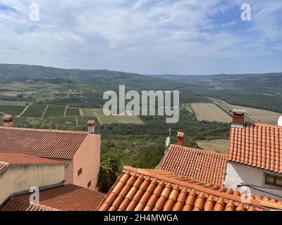 Scena rurale con case dai tetti in tegole rosse e paesaggi scenografici sullo sfondo Foto Stock