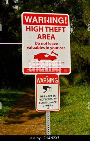 Segnale di avvertenza High Theft Area, che indica la minaccia regolare di vandalismo del veicolo o di break-in o furto, telecamera di sorveglianza, a Oahu, Honolulu, Hawaii, USA Foto Stock