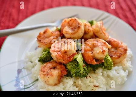 Il famoso gambero all'aglio North Shore servito su broccoli e riso su un piatto bianco, Oahu, Hawaii, USA Foto Stock