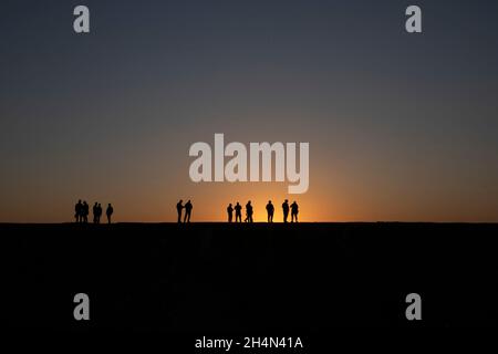 Le silhouette dei Controllori di attacco tattico iracheno (ITAC) dei Controterrorism Services and Coalition Joint Attack Controllers (JTAC) sono viste come continuano fino alla sera quando hanno partecipato all'esercizio dei Phoenix Firs vicino alla base aerea di al Asad, Iraq, 22 ottobre 2021. Il gruppo ha partecipato all'esercizio Phoenix Fires per consentire agli ITAC di perfezionare le loro competenze. (STATI UNITI Esercito Foto di personale Sgt. Jose A. Torres, Jr.) Foto Stock