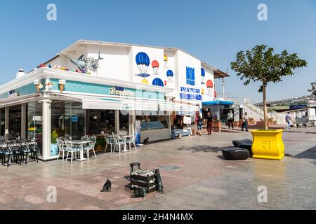 Kusadasi, Aydin, Turchia – 6 ottobre 2020. Mercato del pesce in Kusadasi località turistica in Turchia. Vista esterna con statue di gatti, caffè e gente. Foto Stock