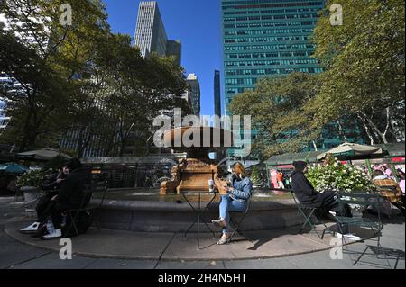 New York, Stati Uniti. 03 novembre 2021. Una donna siede accanto alla fontana mentre la Bank of America Winter Village riapre a Bryant Park, New York, NY, 3 novembre 2021. Lo spazio urbano è allestito con chioschi per lo shopping, posti a sedere laterali sulla pista e area bar. (Foto di Anthony Behar/Sipa USA) Credit: Sipa USA/Alamy Live News Foto Stock