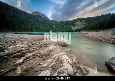 Spettacolari cieli colorati e la luce in una famosa area escursionistica, con il Monte Durmitor con paesaggi glaciali e terreno, a fine estate, in alto nel Foto Stock