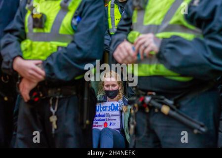 Glasgow, Regno Unito. 03 novembre 2021. Un attivista che tiene un cartello incollato sul marciapiede al di fuori della SSE (Scottish and Southern Energy plc) su Waterloo Street durante la protesta.come prosegue la Conferenza delle Nazioni Unite sui cambiamenti climatici (26a Conferenza delle parti (COP26)), Extinction Rebellion e altri gruppi di attivisti per il cambiamento climatico hanno tenuto un raduno presso Glasgow Royal Concert Hall Steps, Buchanan Street, e stanno marciando attraverso le strade del centro di Glasgow. Credit: SOPA Images Limited/Alamy Live News Foto Stock