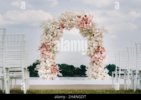 Cerimonia di nozze sulla strada sul prato verde.decorazione di una celebrazione di nozze. Foto Stock