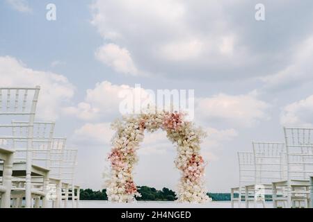 Cerimonia di nozze sulla strada sul prato verde.decorazione di una celebrazione di nozze. Foto Stock