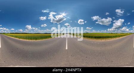 Visualizzazione panoramica a 360 gradi di vista panoramica senza giunture hdri 360 su strada asfaltata tra i campi in estate con fantastiche nuvole nel cielo blu in proiezione sferica equirettangolare, re