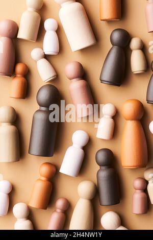 Vista dall'alto di semplici figurine di adulti e bambini multirazziali che rappresentano la diversità nella società su sfondo beige Foto Stock