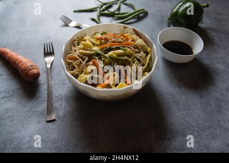 Primo piano di spaghetti schezwan fritti in una ciotola. Foto Stock