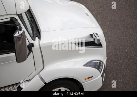 Per uso professionale di livello industriale, il potente trattore semi-dumper con carro di perforazione grande e bianco brillante senza il semirimorchio che corre lungo l'ampia strada statale fino al wareho Foto Stock