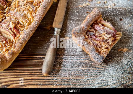 Sana prima colazione torta di mele con condimento di mandorle. Cotto con farina integrale e pasta di lievito. Servita su sfondo di legno Foto Stock