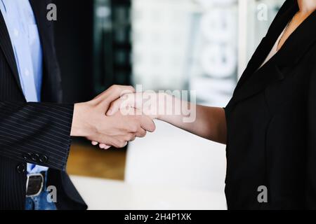 Congratulazioni, i proprietari di 2 aziende stanno tenendo le mani per congratularsi con loro per i loro investimenti in joint venture. Foto Stock