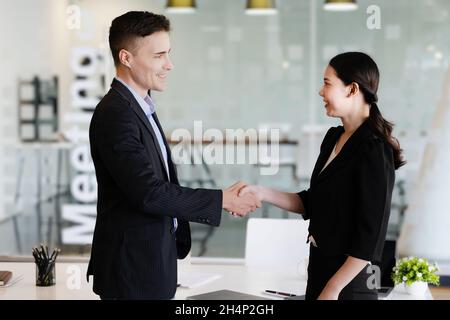 Congratulazioni, i proprietari di 2 aziende stanno tenendo le mani per congratularsi con loro per i loro investimenti in joint venture. Foto Stock