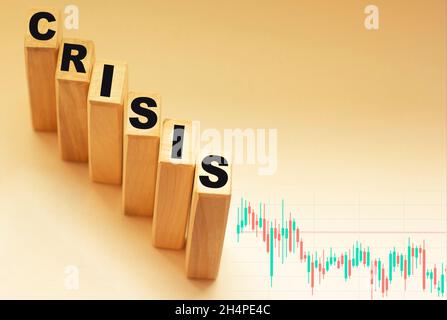 Testo crisi su blocchi di legno e grafico su sfondo chiaro Foto Stock