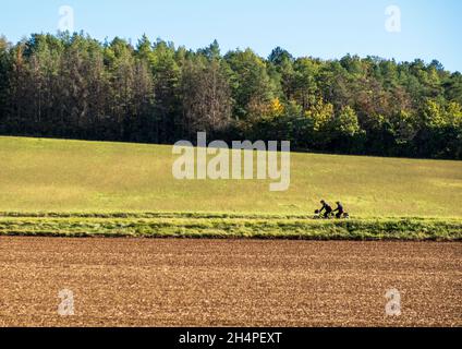 Due ciclisti in tandem sulla strada D100 in Francia rurale, seguendo il percorso del fiume Yonne e Canal du Nivernais Foto Stock