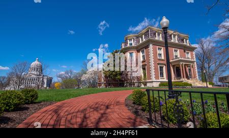 Jefferson City, MO--28 marzo 2021; recinzione decorativa in ferro circonda i terreni del palazzo dei governatori del Missouri con l'edificio del campidoglio dello stato nel retro Foto Stock