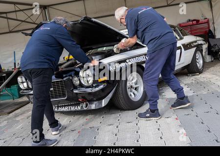 Il meccanico prepara il 1970 Chevrolet Camaro Z28 Gerry Marshall Trophy entrante nel garage del paddock al Goodwood 78th Members Meeting, Sussex, Regno Unito. Foto Stock