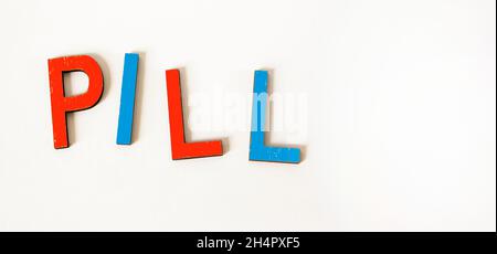 LA PILLOLA di parola consiste di lettere di legno colorate su uno sfondo bianco. Foto Stock