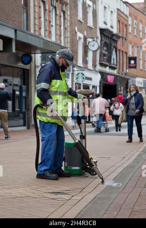 Impiegato del consiglio che usa la macchina di rimozione della gomma da masticare sulla High Street di King's Lynn. Foto Stock